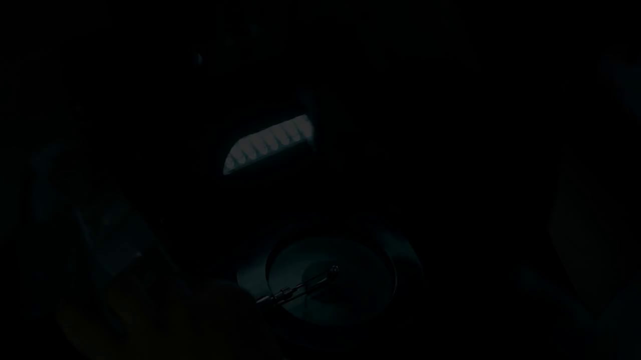Opening frame of the manufacturing film: a jewelry workbench beneath a task light.