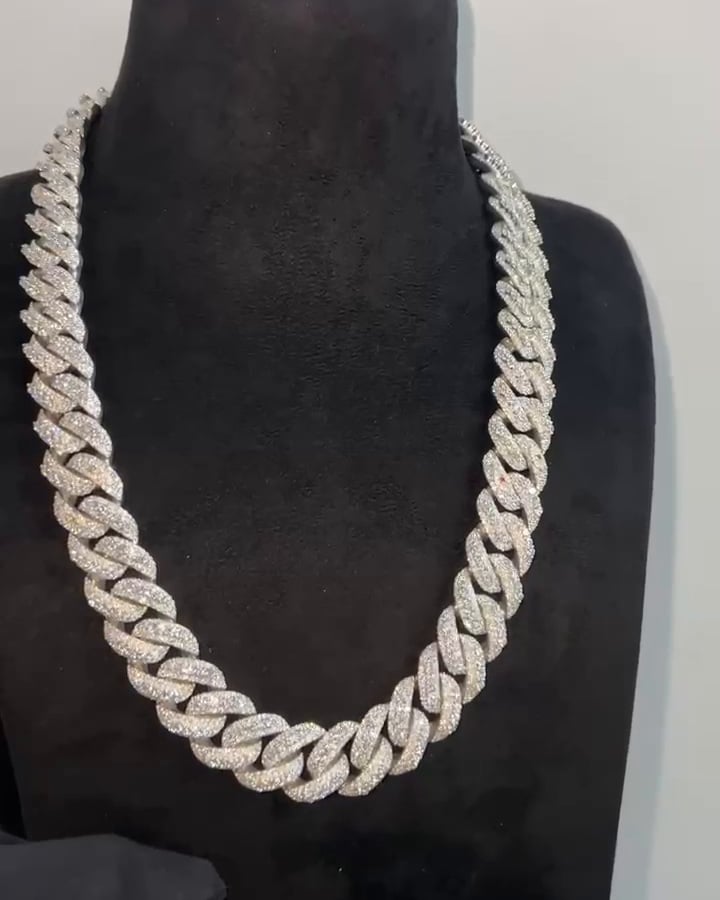 Broad stone-set Cuban-style chain displayed around a dark necklace bust.