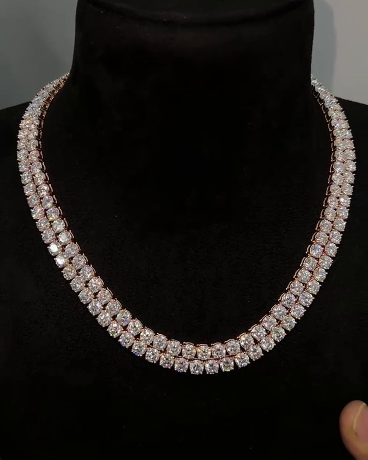 Two closely layered rows of round stone settings displayed on a dark necklace bust.