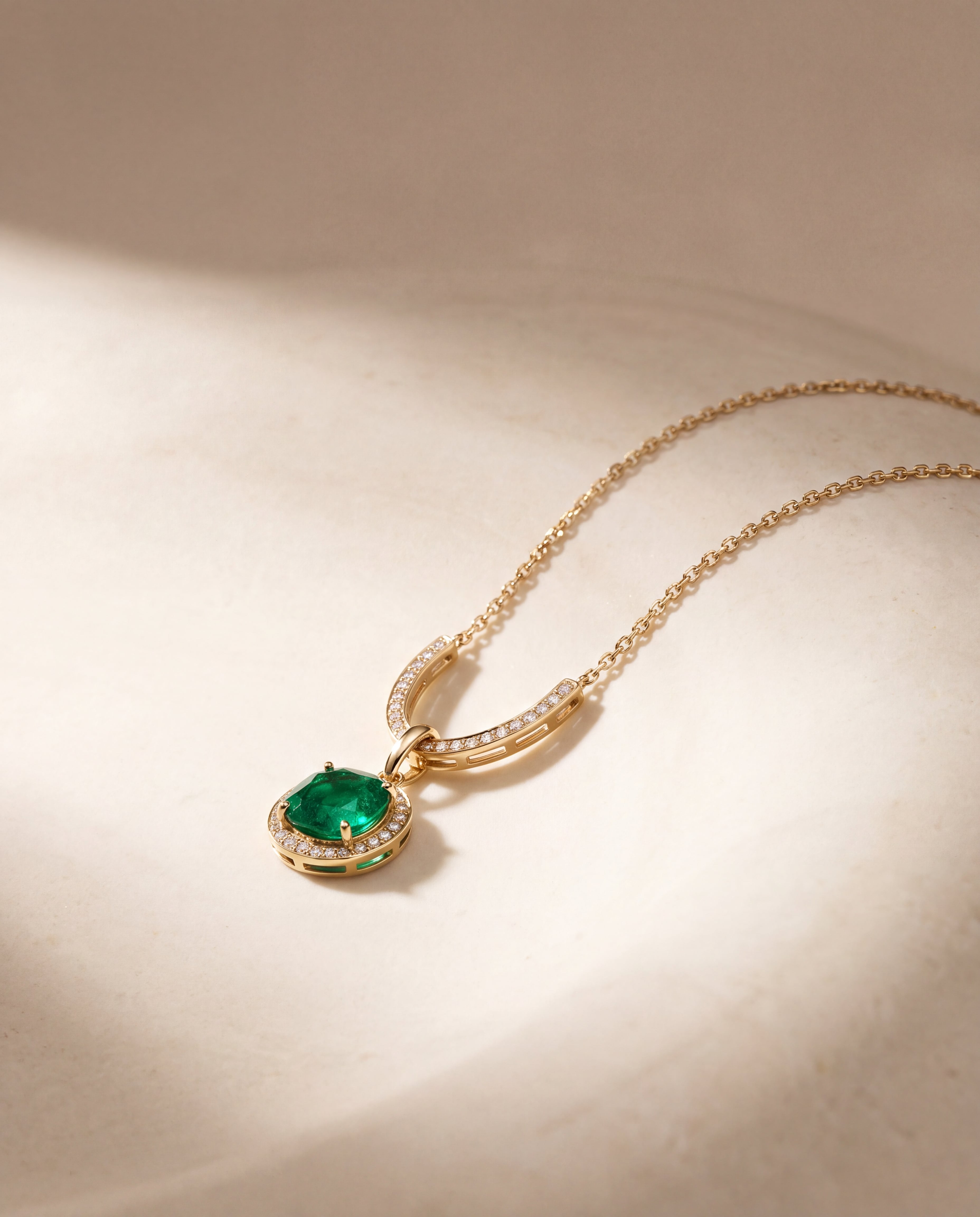 A gold-tone necklace with a green pendant and clear accents on pale stone.